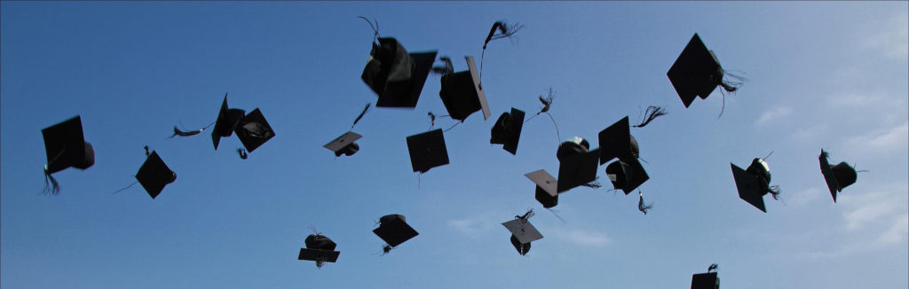 Graduation caps being thrown in the air