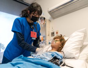 A nursing student works in a simulation lab in the school of nursing