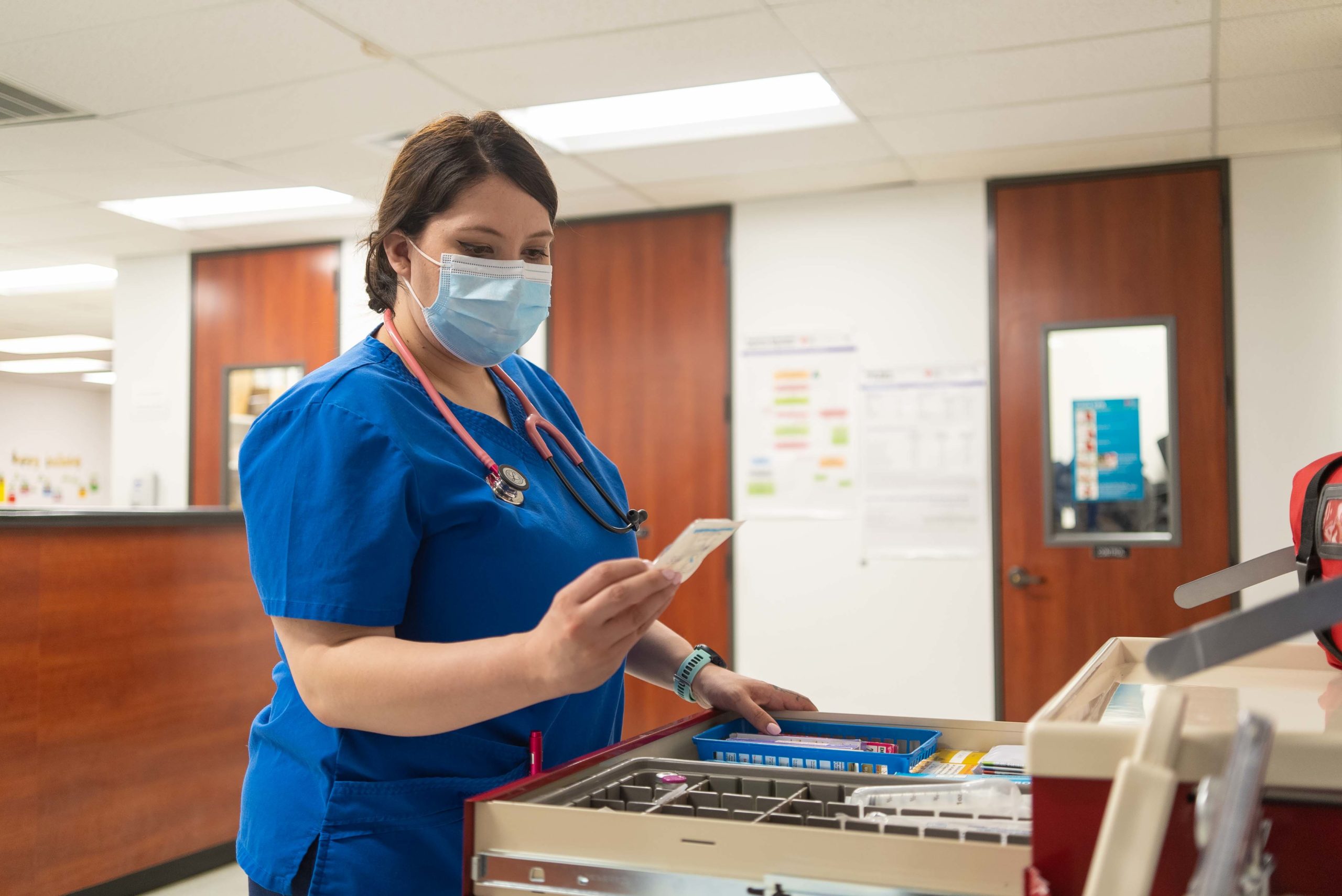 A nursing student examines a packet of medical supplies in the nursing lab at Hallmark University